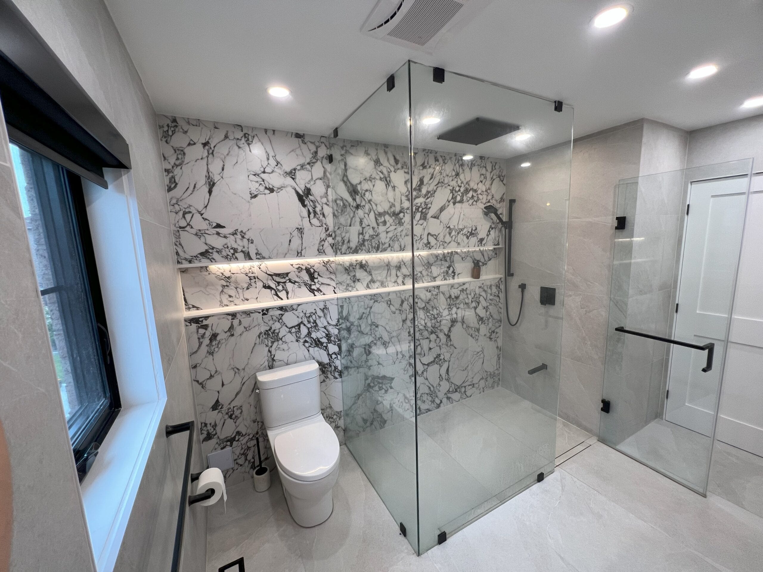 Modern bathroom renovation by GMC Construction Inc. in Toronto, featuring a walk-in shower, contemporary fixtures, and elegant tile work.