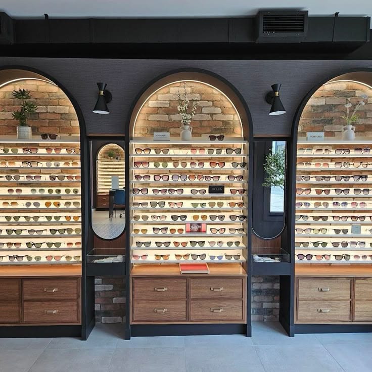 Interior of a modern eyewear store in Toronto after a luxury store renovation, with custom lighting and wood ceiling details
