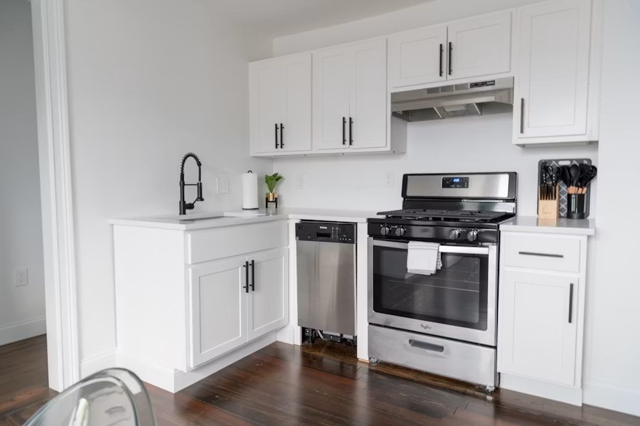 Basement kitchen with cabinetry and ventilation